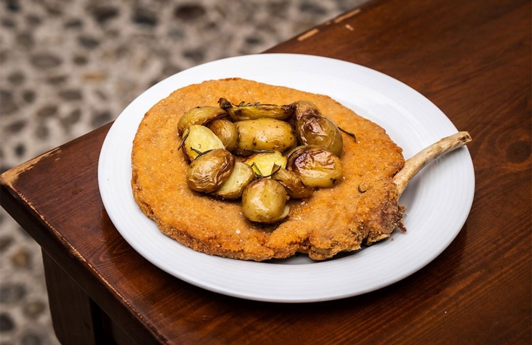 Cotoletta di vitello alla milanese panata e fritta servita da Rosso Brera Cotoletta di vitello alla milanese panata e fritta servita da Rosso Brera